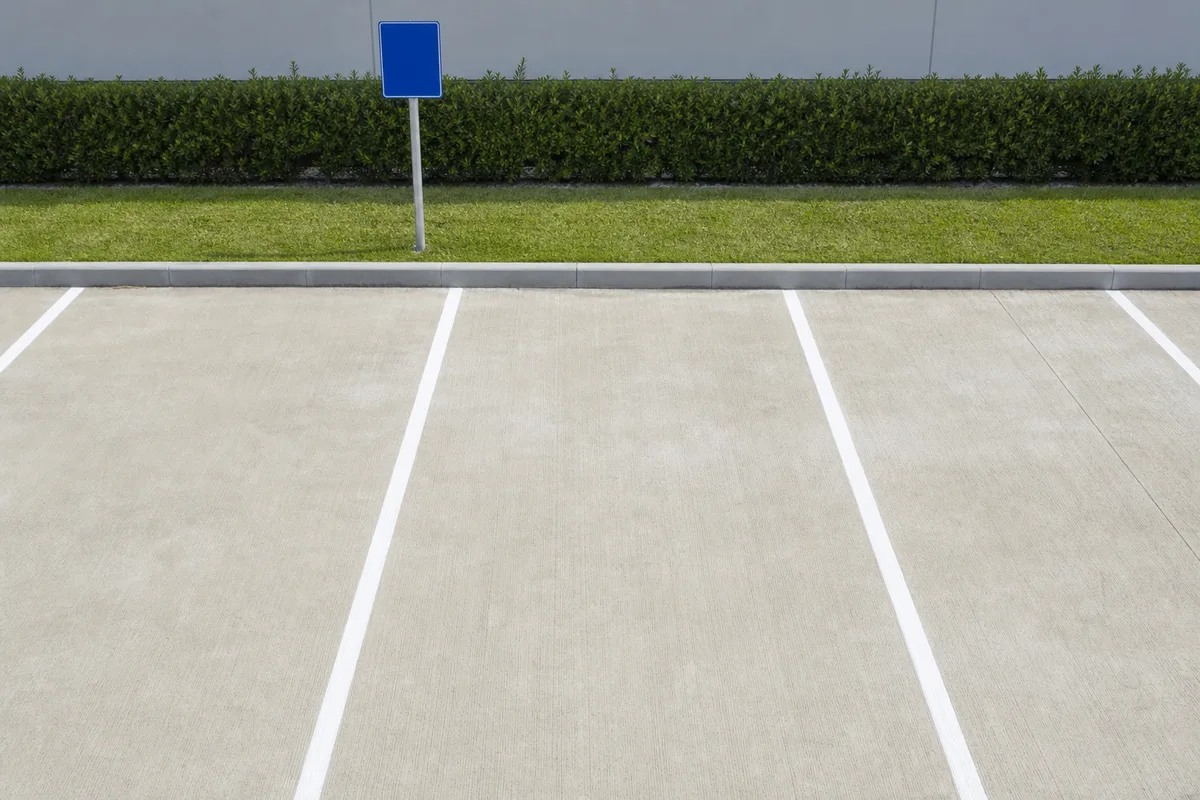 Marquage au sol blanc délimitant les places d’un parking privé